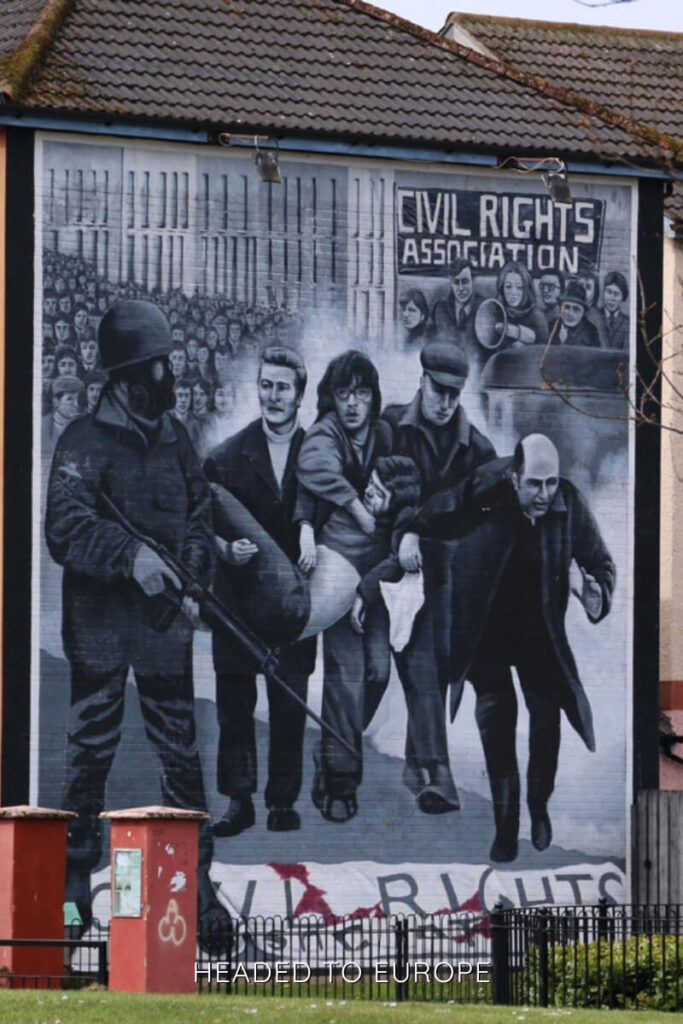 A striking mural in Derry/Londonderry depicts a civil rights protest, offering cultural depth and historical insight during Weekend Breaks in Ireland.