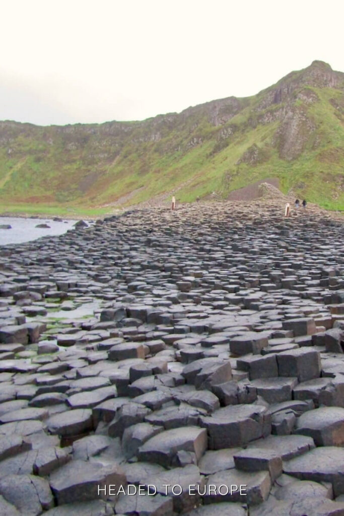 The famous hexagonal basalt columns of Giant’s Causeway stretch along the coast under misty skies, a geological wonder ideal for Weekend Breaks in Ireland.