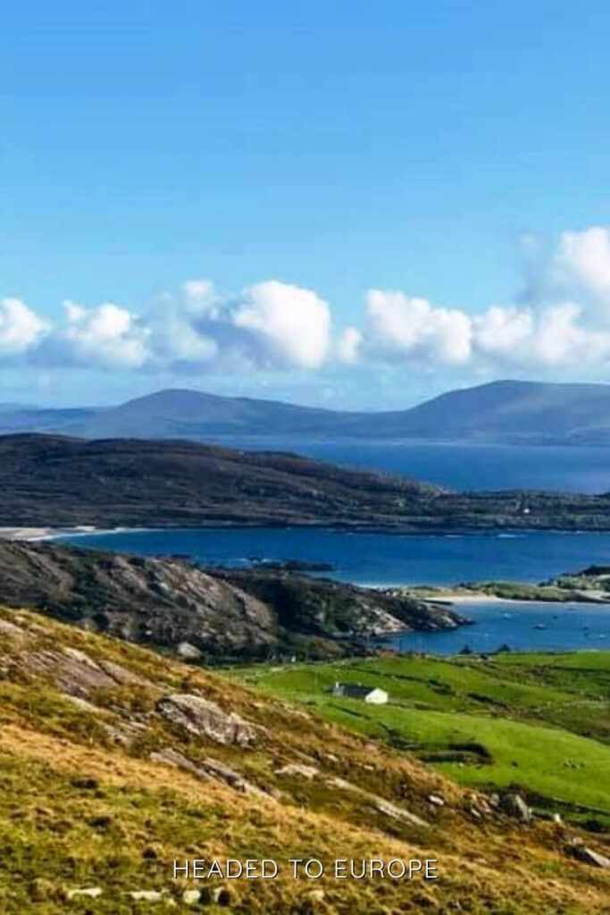 Panoramic view of rugged hills and deep blue waters along the Ring of Kerry, a must-see on scenic Weekend Breaks in Ireland.